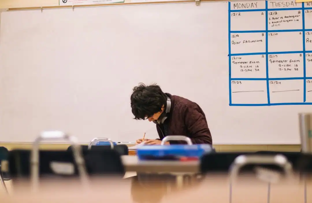 Upper elementary student writing at a classroom desk